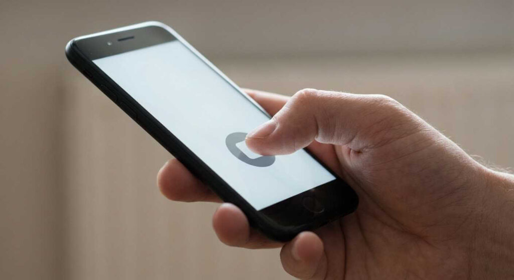 Hand holding a smartphone using a push-to-talk button in a walkie-talkie style app.