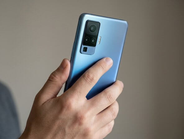 Illustration of a hand holding the vivo X500 Pro Max below its rear camera housing